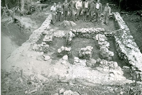 eine Gruppe von Männern steht in der Mitte der Ausgrabungen