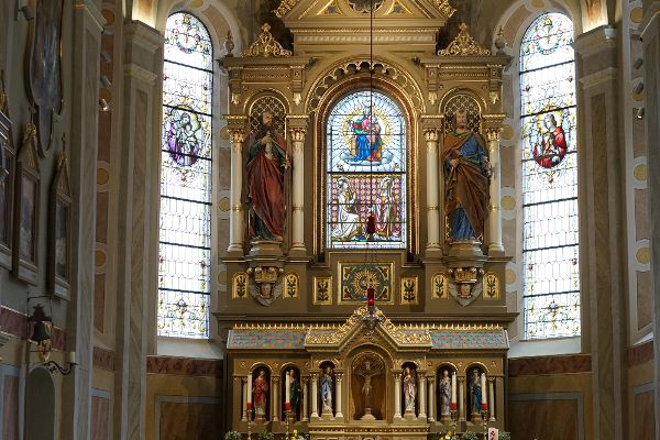 Pfarrkirche Arzl im Pitztal - Blick in den Chor zum Hochaltar. Das zentrale Glasfenster mit der Darstellung der Kirchenpatrone bildet gleichzeitig das Hochaltarbild.