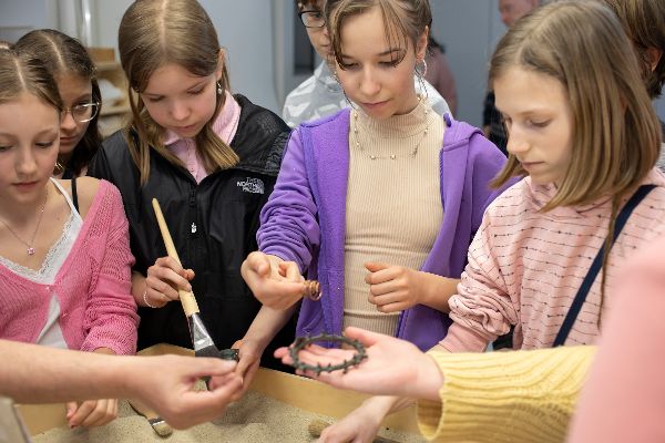 Mädchen halten archäologische Fundstücke in der Hand
