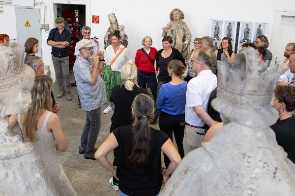 Eine Gruppen von Menschen steht in einer Halle mit großen Figuren aus Sandstein
