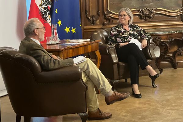 ein Mann und eine Frau sitzen einander im Gespräch gegenüber