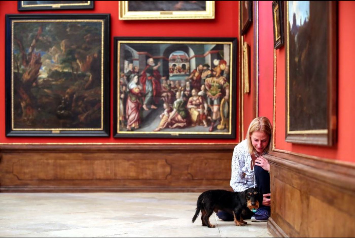 eine Frau und ein Hund sind in einem Museum