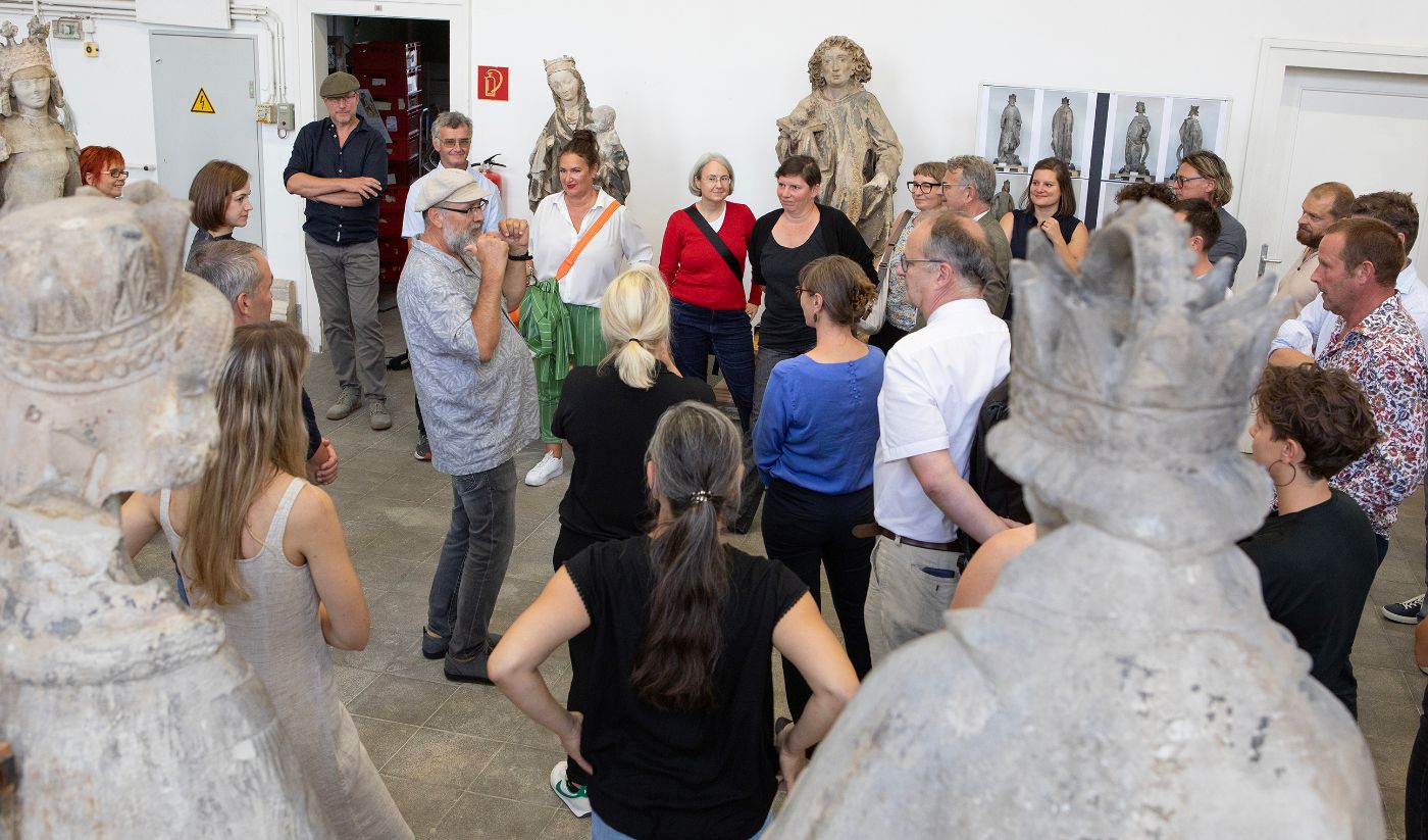 Eine Gruppen von Menschen steht in einer Halle mit großen Figuren aus Sandstein
