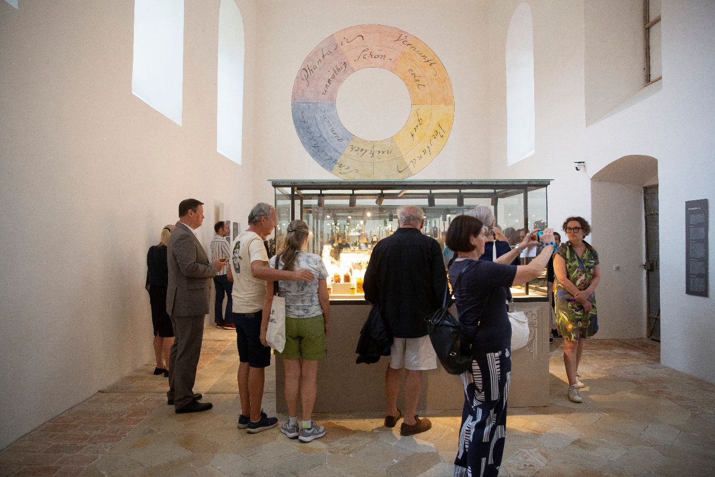 Blick in den Raum der Ausstellung "Farbgeschichten" in der Kartause Mauerbach mit Goethes Farbenkreis an der Wand
