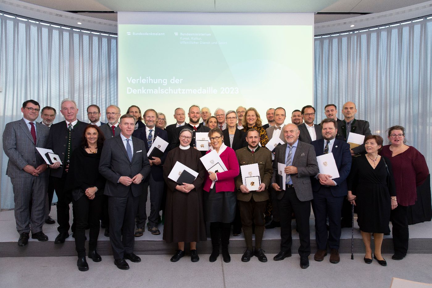 Gruppenfoto Dr. Christoph Bazil, Präsident des Bundesdenkmalamtes und Verwaltungsdirektor Dr. Heinz Schödl mit den Preisträger:innen der Denkmalschutzmedaille 2023