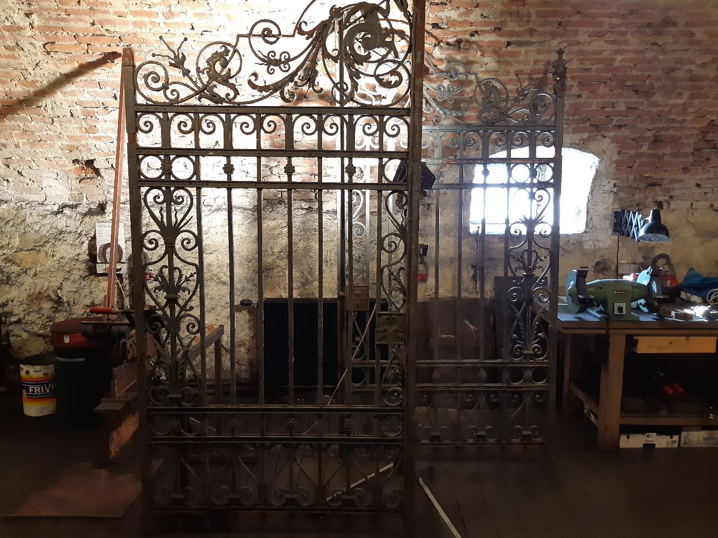 Blick in eine Werkstatt mit verschiedenen Gittertoren aus Schmiedeeisen