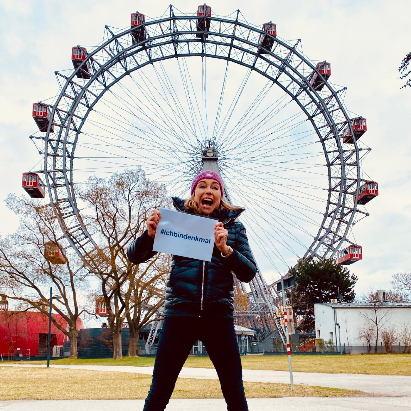 Frau mit SChild vorm Riesenrad in Wien