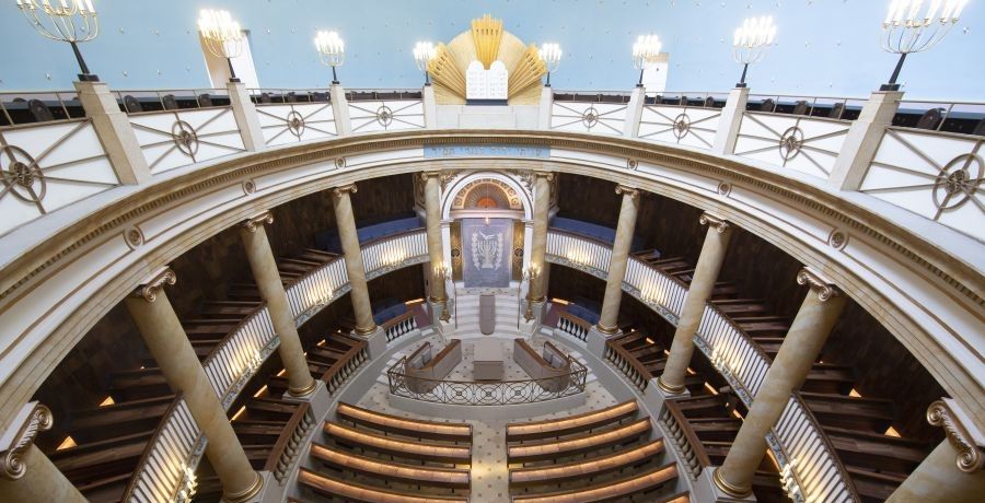 Blick von der Galerie in die restaurierte Synagoge in der Seitenstättengasse mit wiederhergestelltem Steinboden und neuen Stuhlreihen.