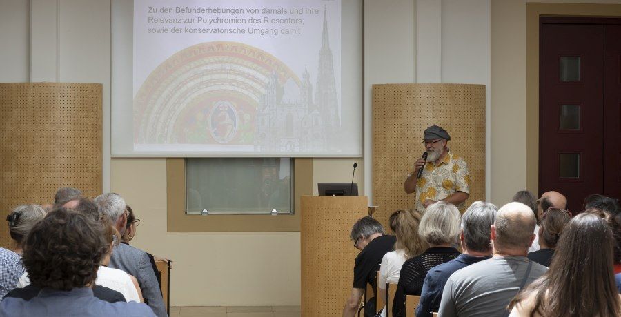 ein Mann spricht in einem Vortragssaal vor Publikum