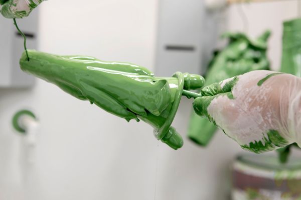 Die einzelnen, circa 30 Zentimeter langen Blatttrichter werden mit grüner Farbe lackiert.