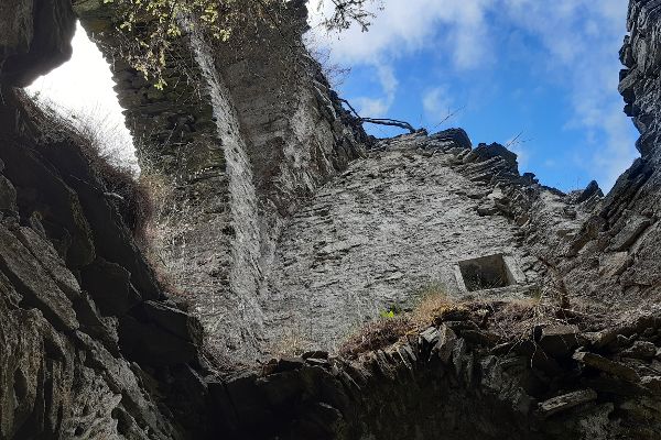 Blick aus dem Inneren einer Burgruine gegen den Himmel