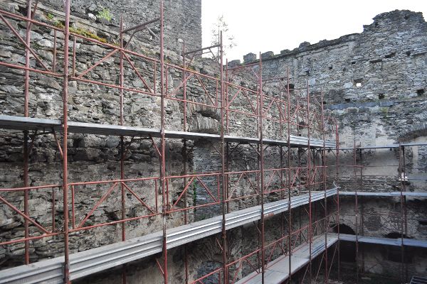 Baugerüst an einer Steinmauer einer Burganlage