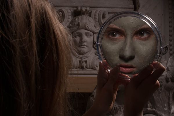 eine Frau schaut in einen Spiegel