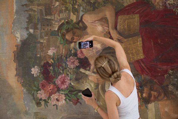 Der Erhaltungszustand des Mozartvorhangs wird von einer Restauratorin mittels Kamera dokumentiert