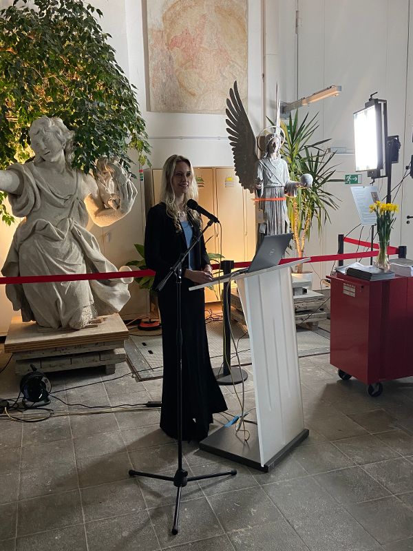 eine Frau spricht in ein Mikrofon an einem Rednerpult