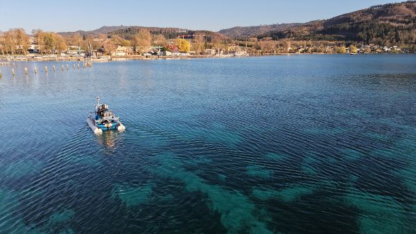 ein Schlauchboot mit wissenschaftlicher Ausrüstung an Bord fährt zu Forschungszwecken am Attersee 