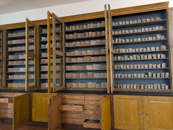eine Gruppe von Studentinnen und Studenten untersucht historische Ziegel und gibt Daten in einen Computer ein