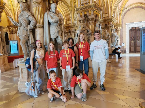 eine Gruppe von Kindern und Erwachsenen steht vor einigen Marmorfiguren in der Feldherrnhalle des Heeresgeschichtlichen Museums in Wien