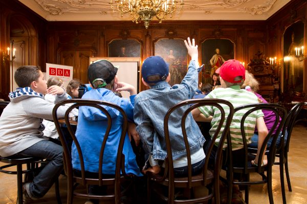 zwei Kinder sitzen im Ahnensaal