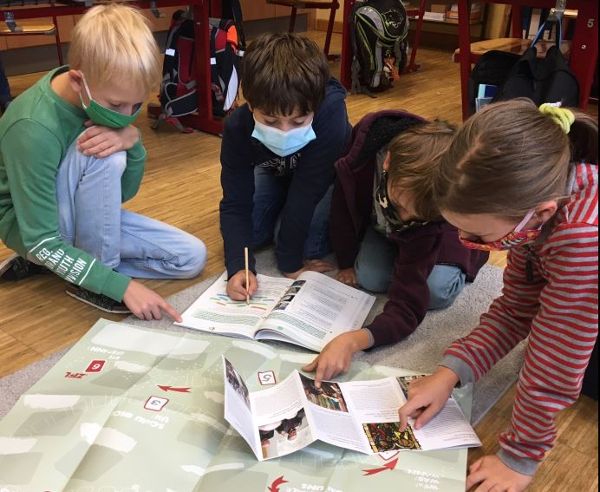 drei Kinder schauen einen Plan an